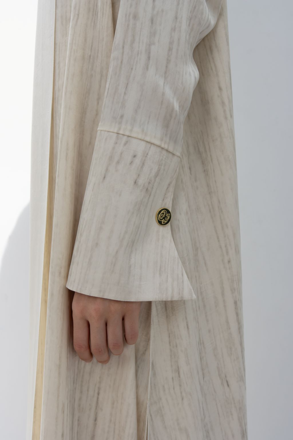 Elegant printed abaya sleeve detail with button from Selected Lines in a soft beige fabric