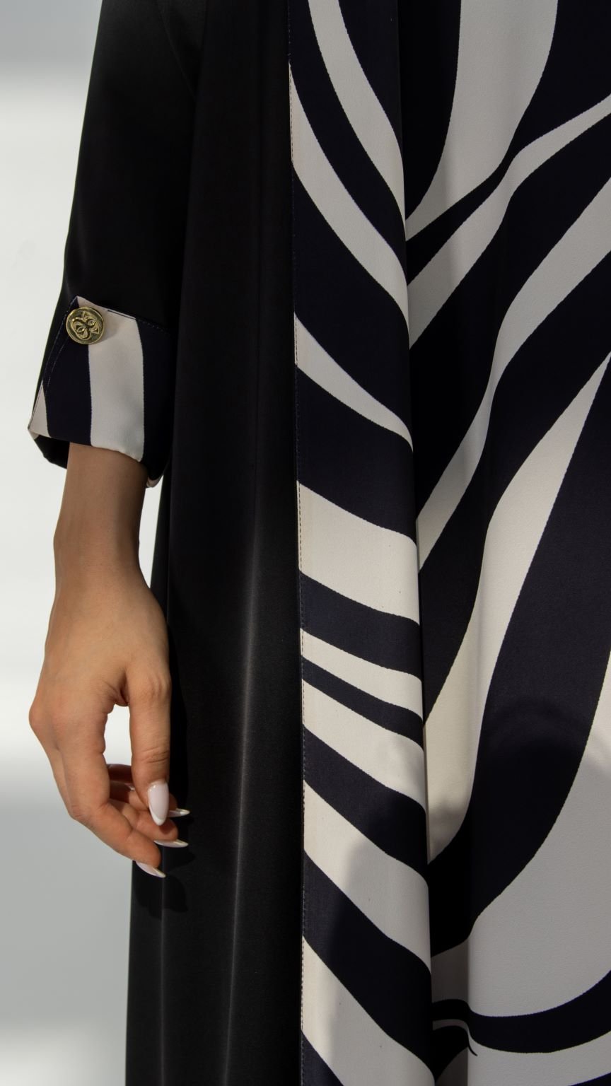 Close-up of Zebra Abaya’s crepe signature fabric and engraved logo buttons | Selected Lines