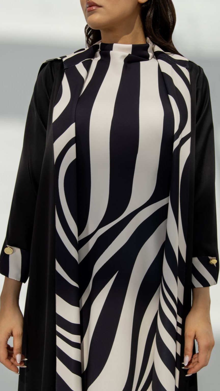 Front view of Zebra Abaya featuring black crepe fabric with signature Z printed material and engraved logo buttons | Selected Lines