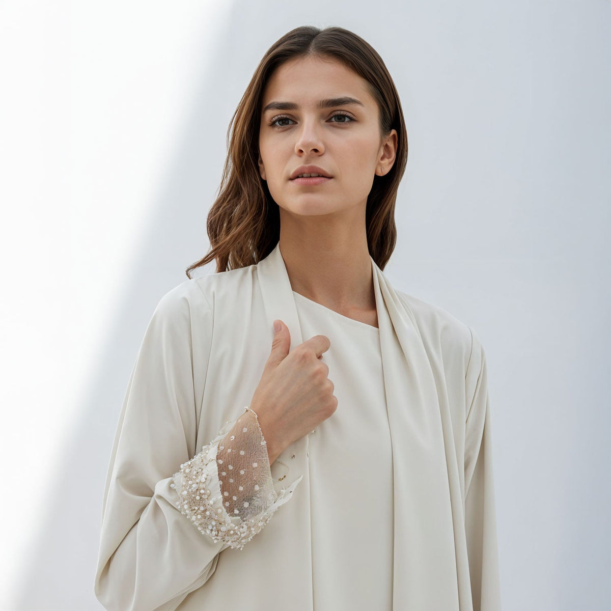 Elegant woman wearing cream outfit with detailed pearl cuffs showcasing refined luxury fashion deals