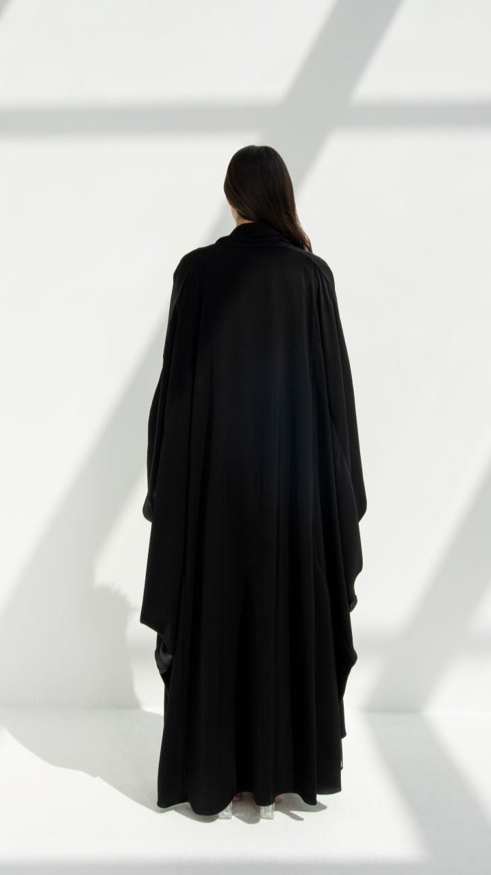 Back view of a woman wearing a luxury Al Zain Abaya by Selected Lines in black fabric