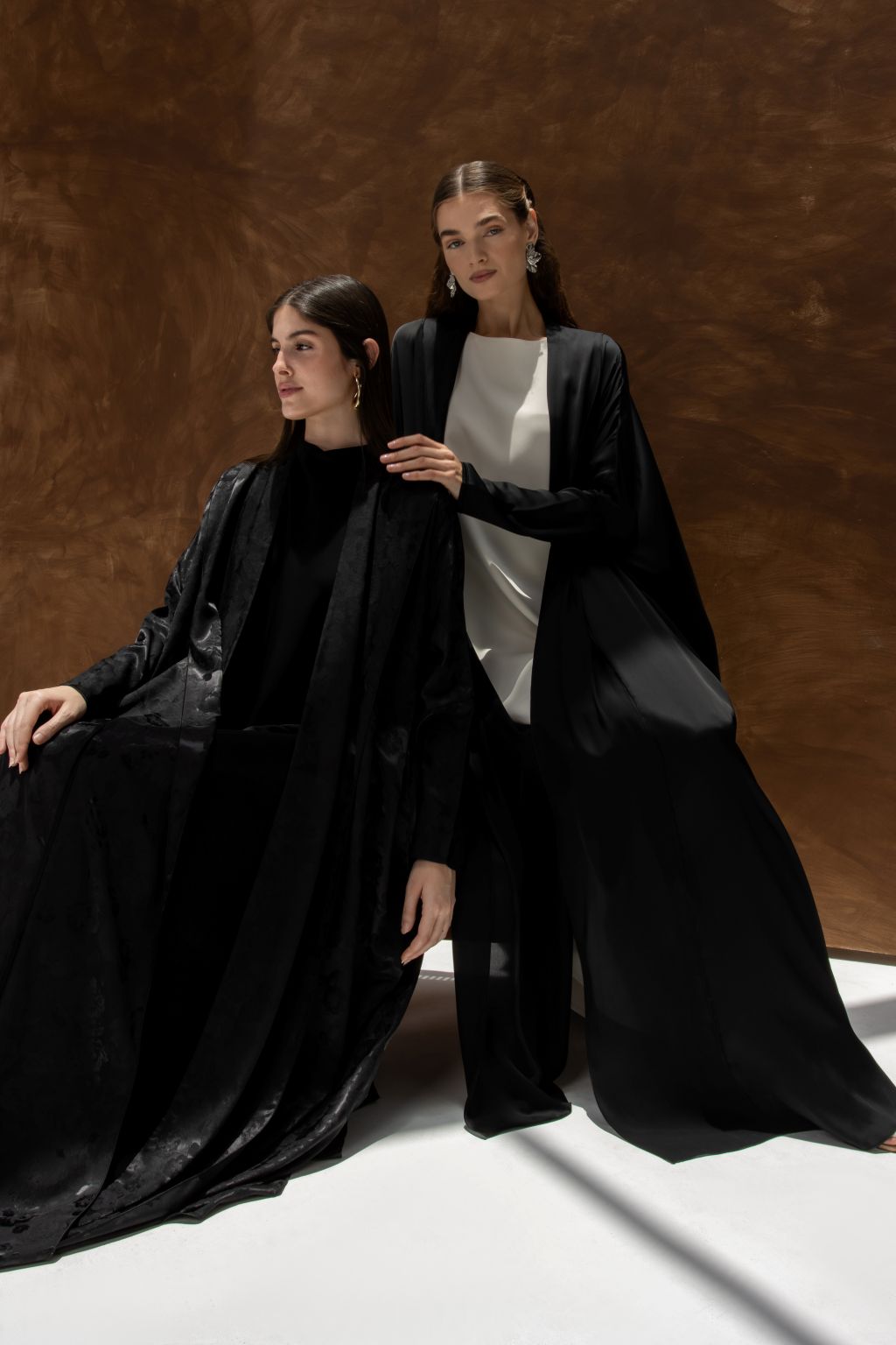 Selected Lines Bahraini abaya for women in elegant black fabric modeled by two women in stylish poses