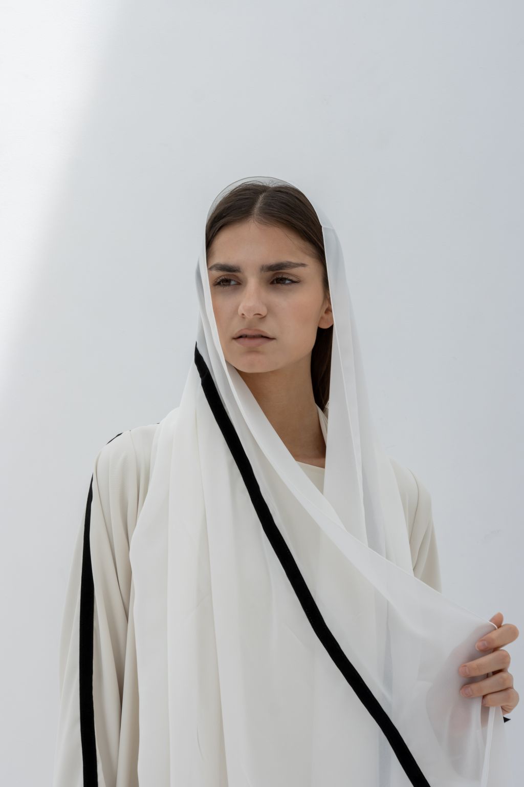 Elegant white abaya with black velvet ribbon for sewing, perfect for stylish layering and special occasions