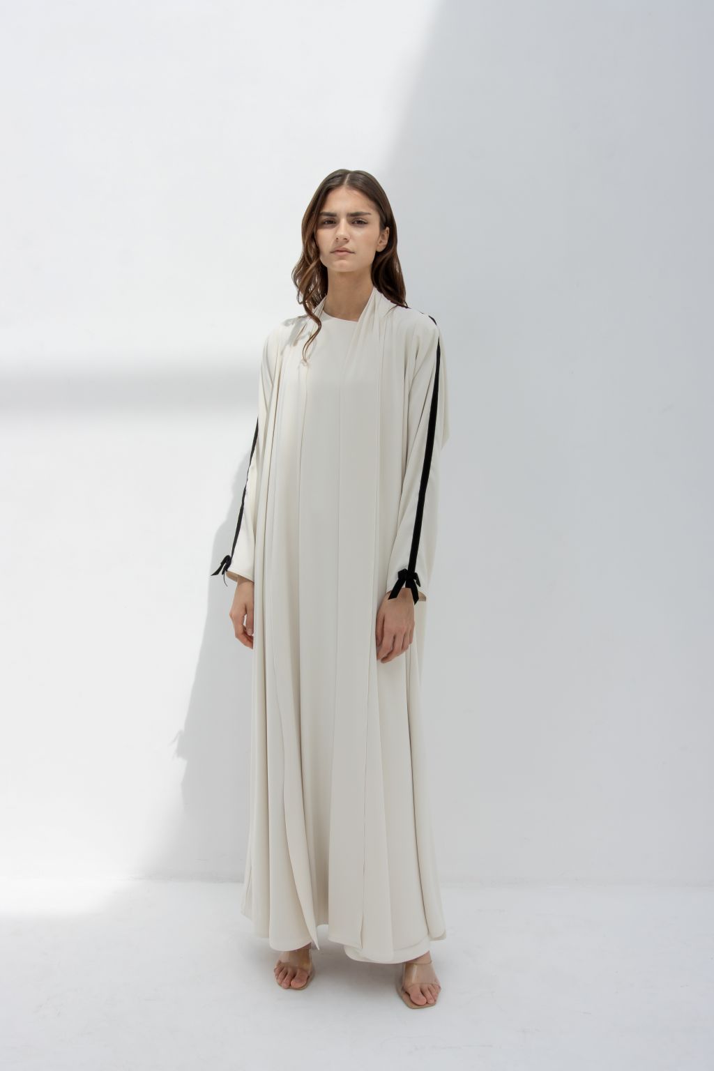 Elegant white abaya featuring black velvet ribbon for sewing on sleeves, perfect for formal occasions