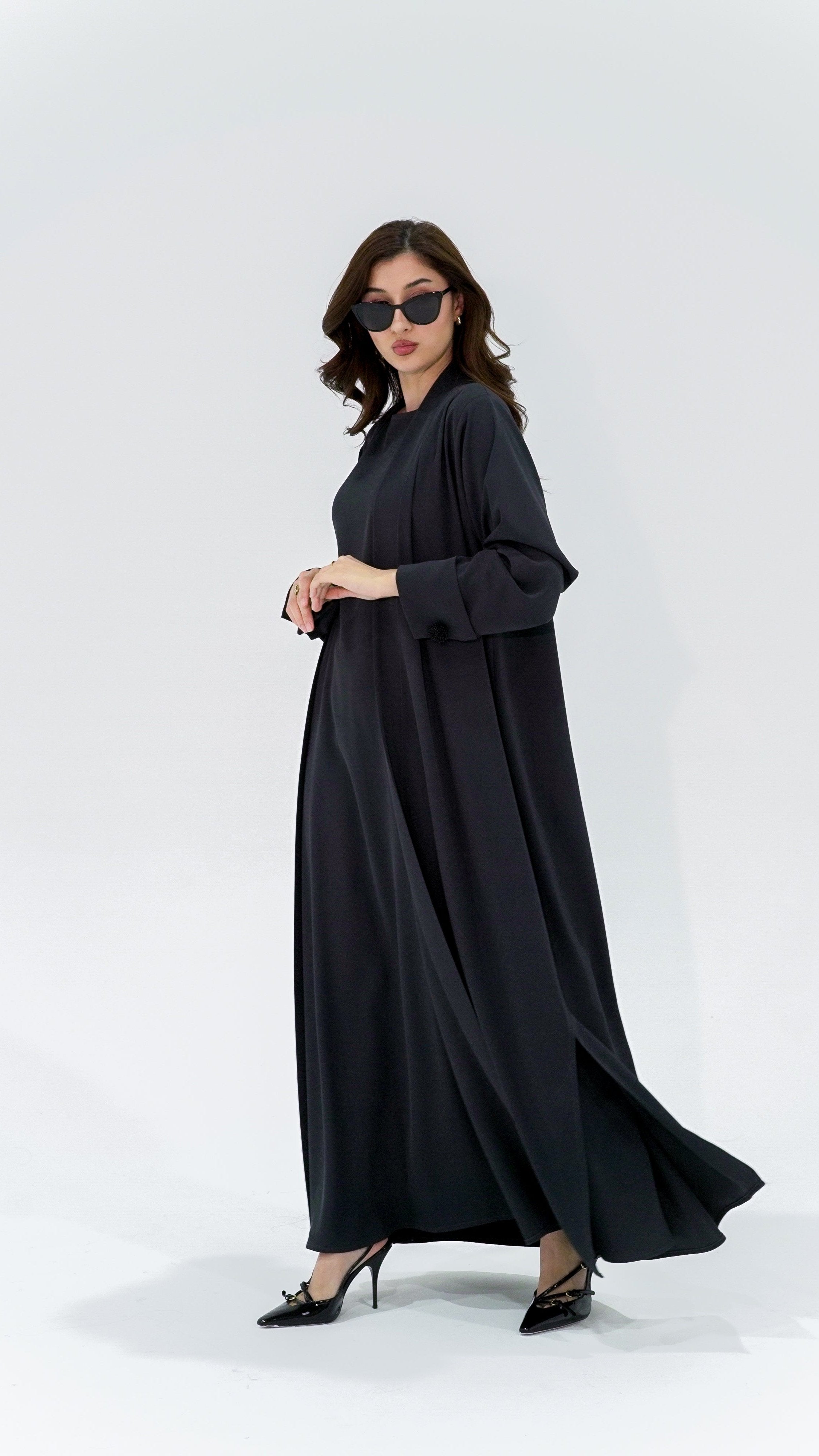 Woman wearing charcoal pearl sleeve abaya from Selected Lines with black sunglasses and heels