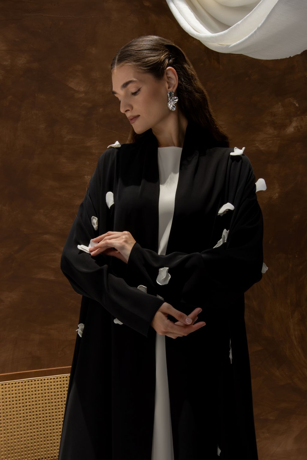 Selected Lines black designer abaya handcrafted details with white accents on sleeves worn by model