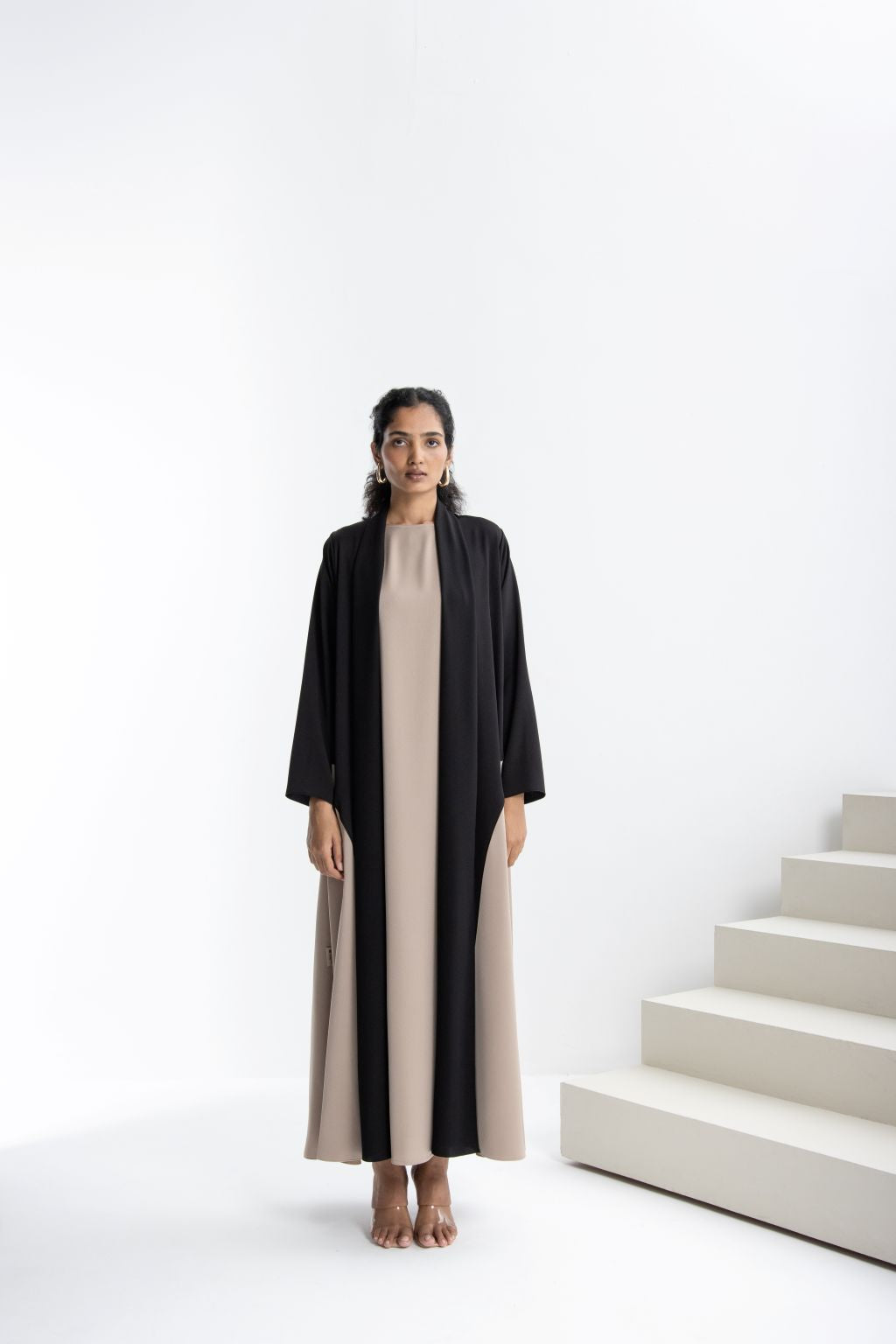 Elegant modest fashion dress featuring a black Abaya and a beige underdress for a chic look