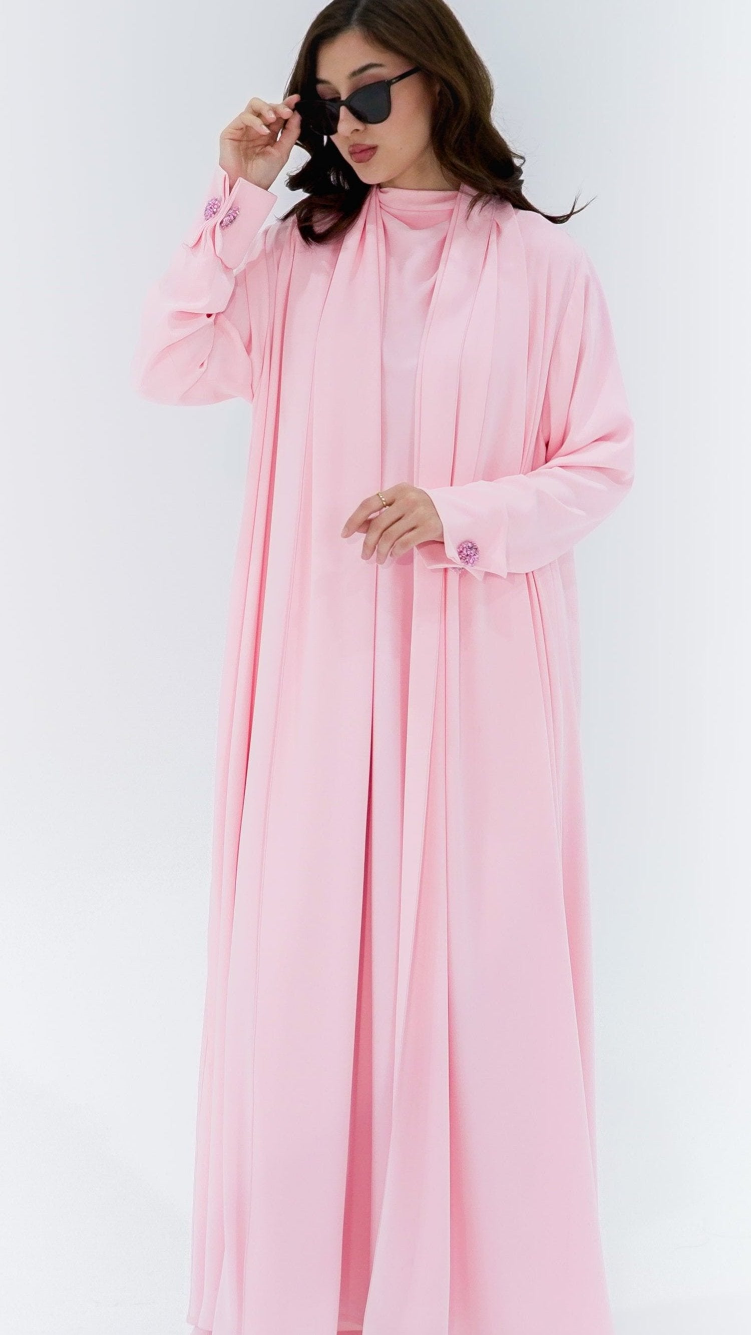 Elegant pearl buttons abaya in soft pink fabric with flowing design and stylish sleeves