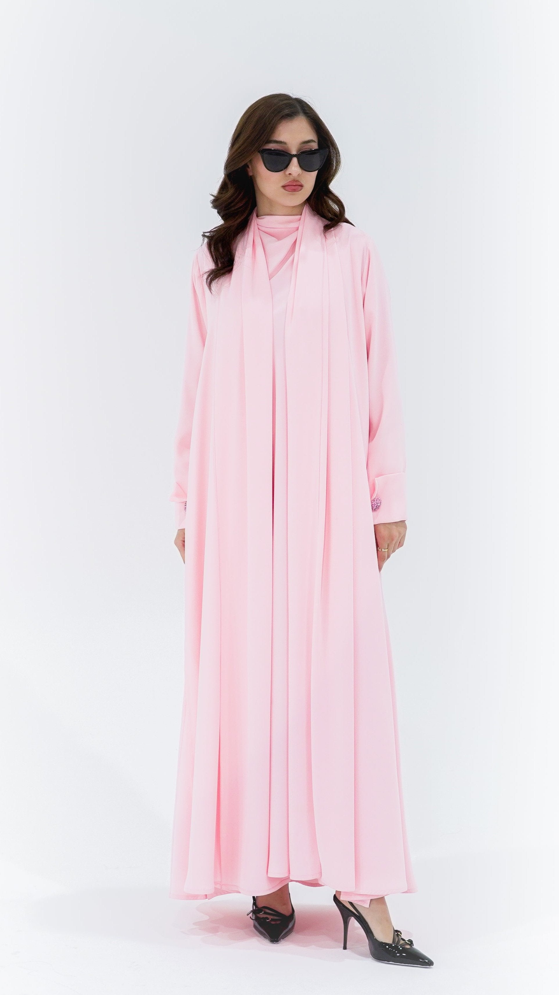 Elegant pearl buttons abaya in soft pink with a flowing design, perfect for stylish occasions