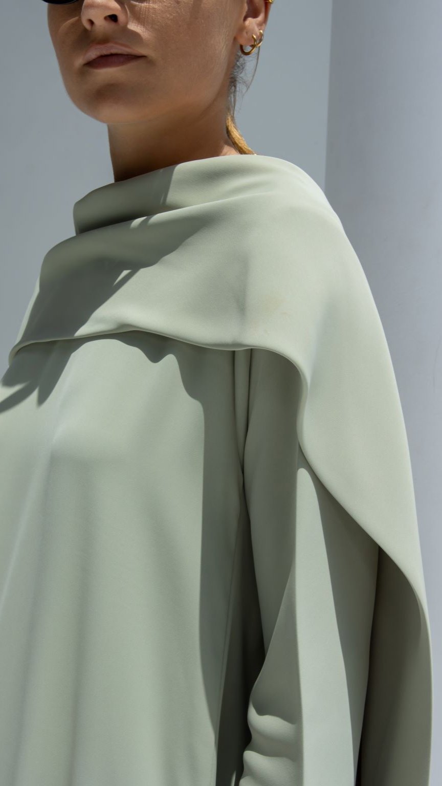 Stylish woman wearing an elegant scarf dress in soft green for a chic summer look