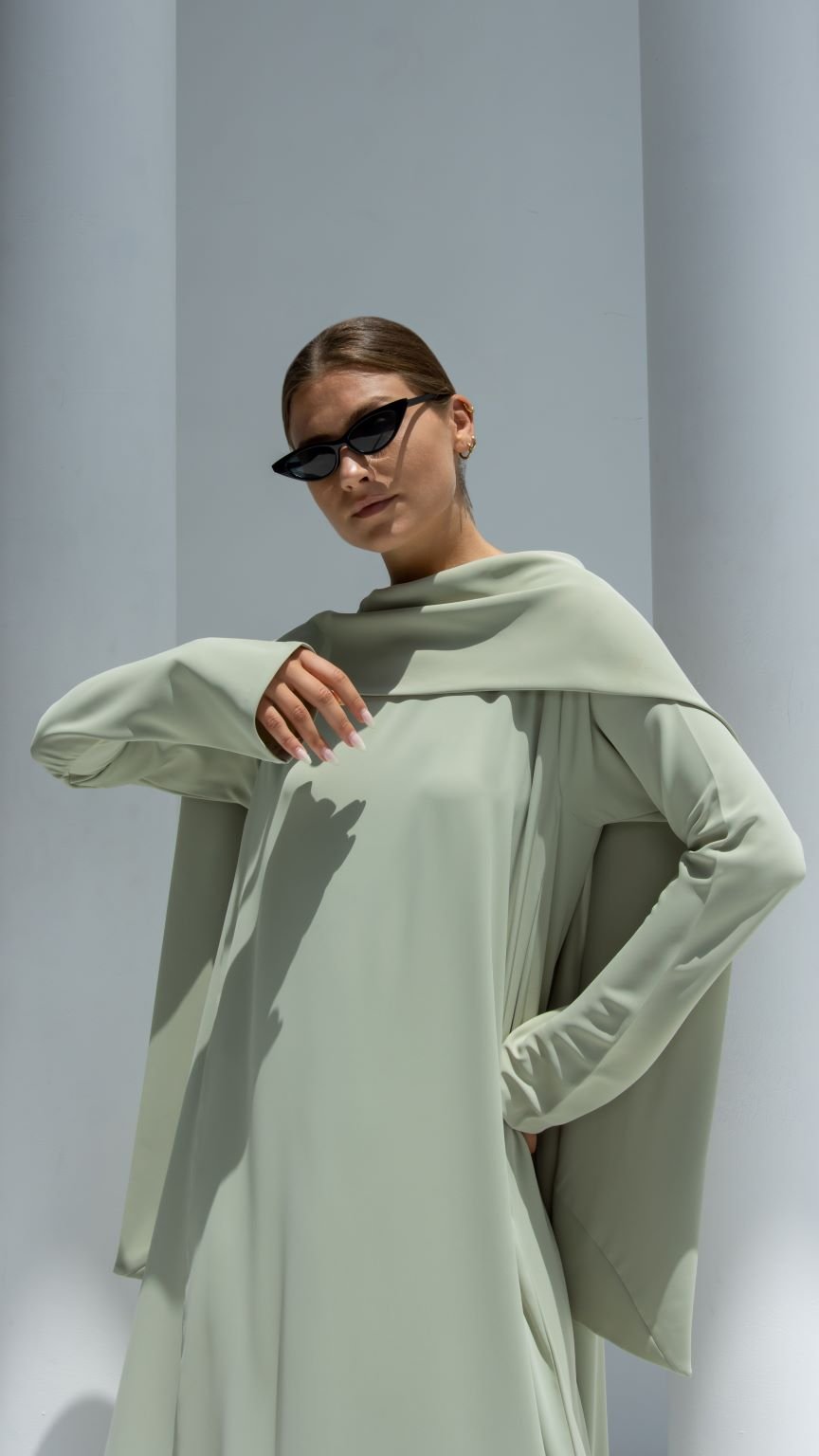 Model wearing an elegant scarf dress in light green with a chic design for stylish occasions