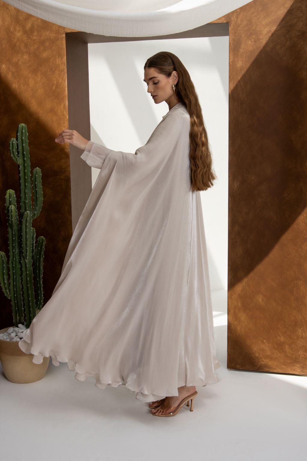 Woman wearing elegant Swan Flow abaya by Selected Lines in soft flowing fabric with ruffled hem