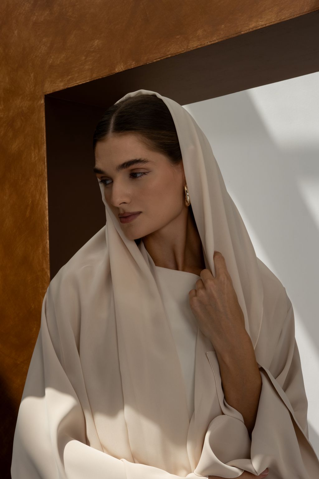 Elegant women’s Franci abaya by Selected Lines in soft beige fabric worn by a woman indoors