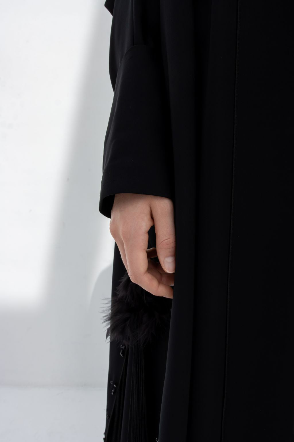 Detail of luxury black abaya featuring elegant fabric and intricate embellishments on the sleeve