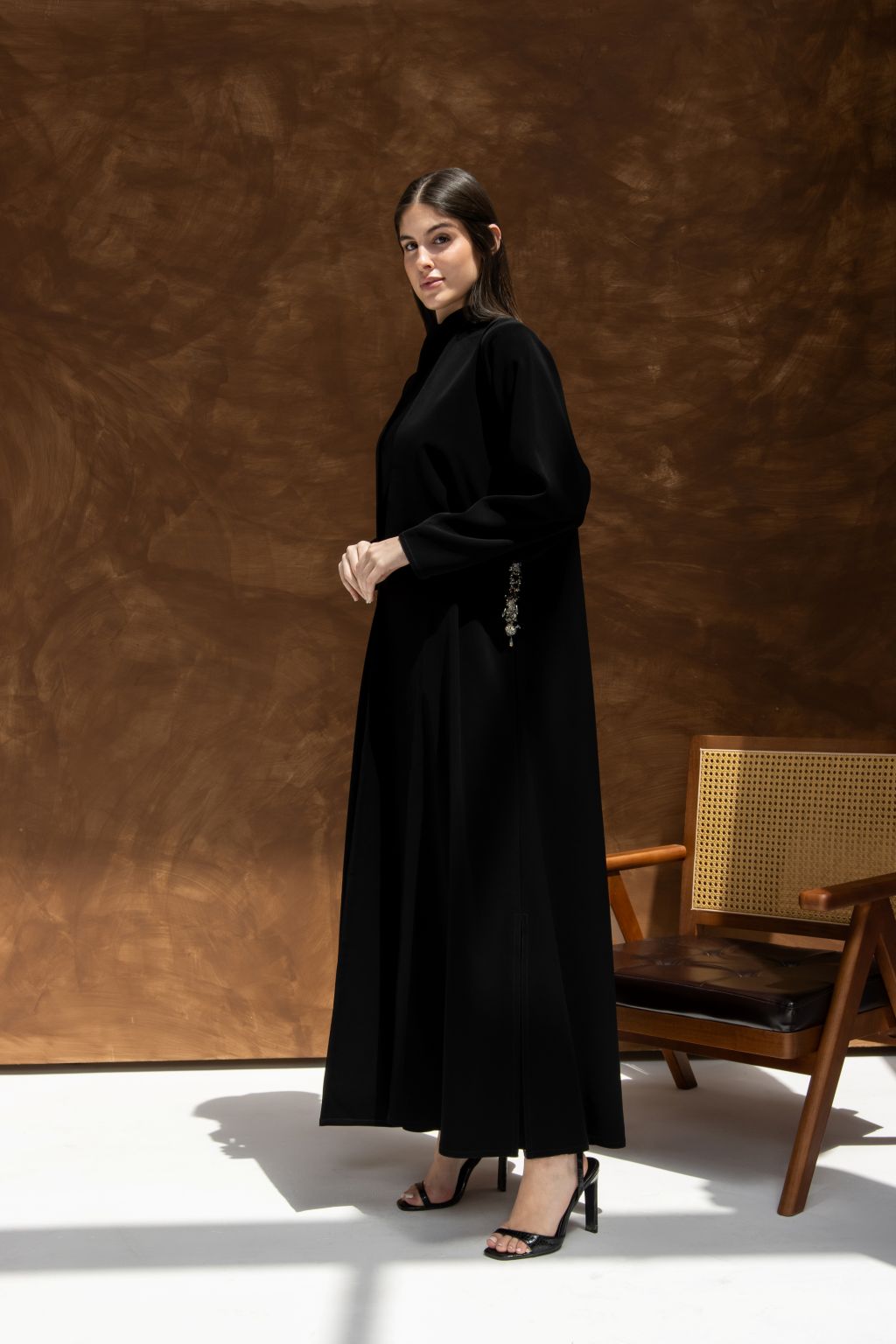Elegant model wearing a luxury black abaya with hidden pockets, showcasing modern design and comfort.
