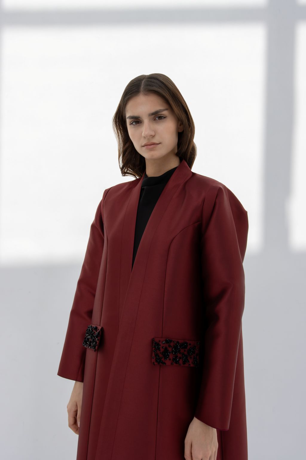 Luxury burgundy women's coat with stylish embellishments and a modern silhouette