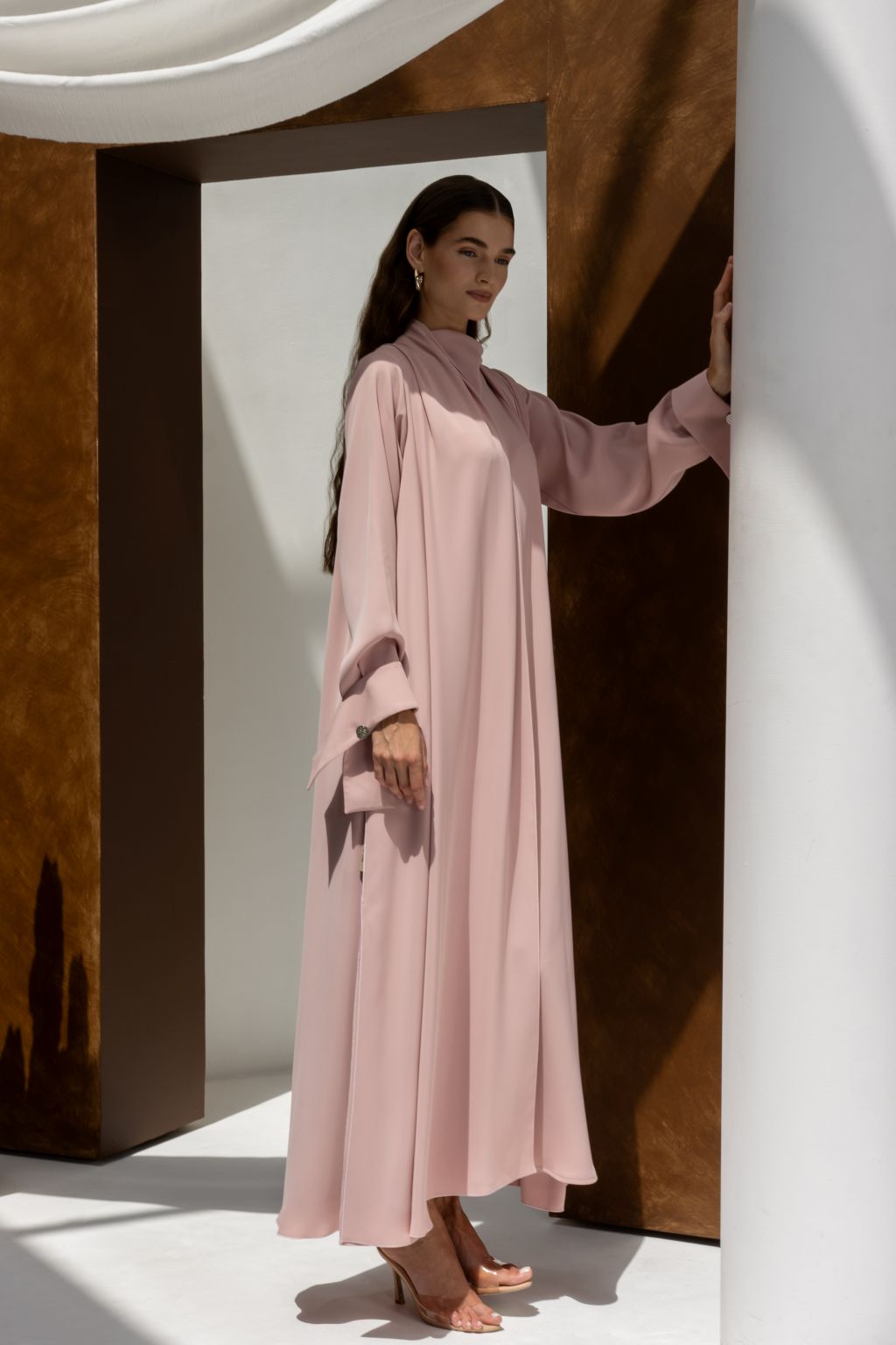 Selected Lines luxury buttoned abaya in soft pink with long sleeves and high collar worn by model