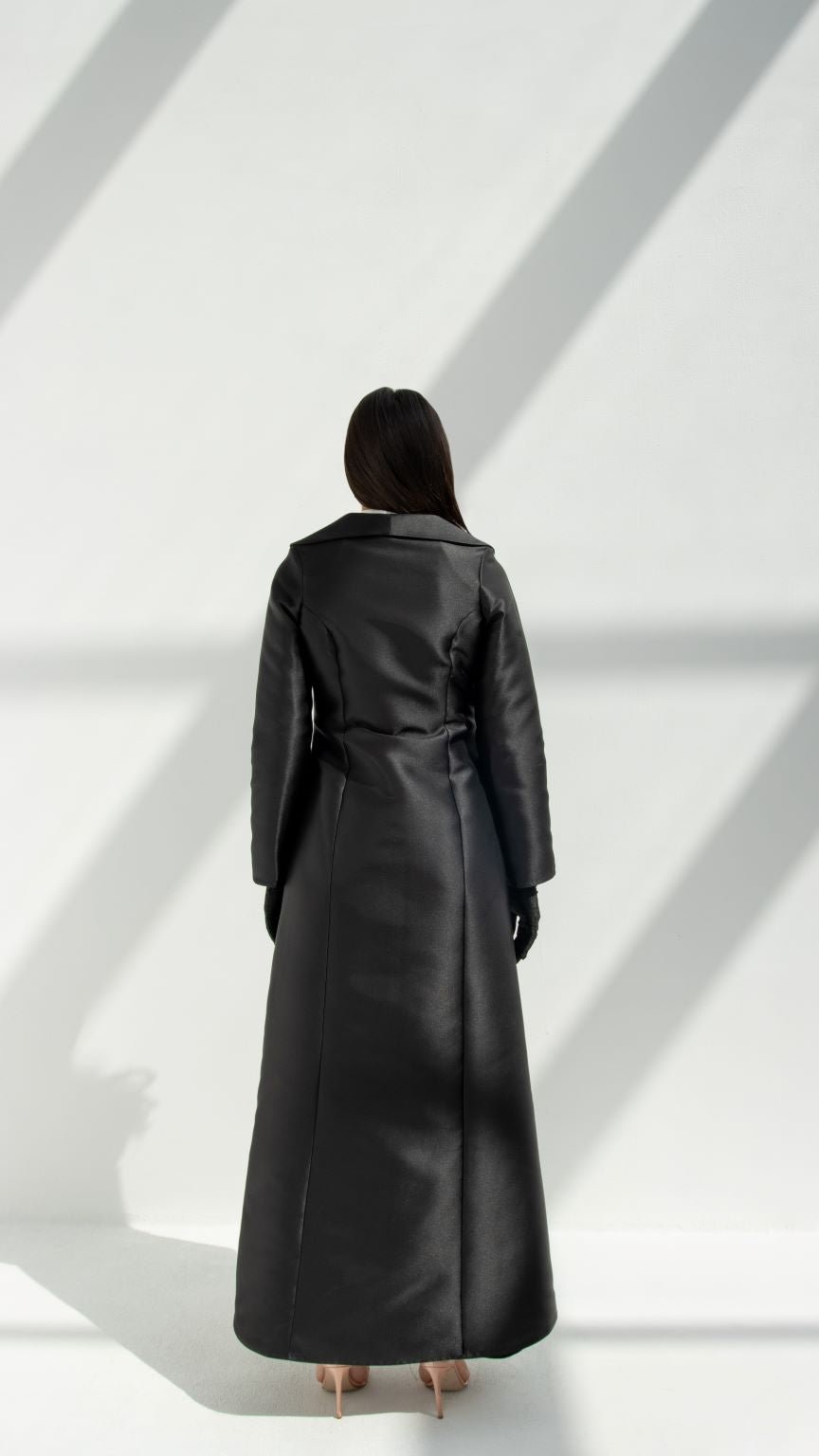 Back view of a woman wearing a black luxury coat abaya by Selected Lines with long sleeves and tailored fit