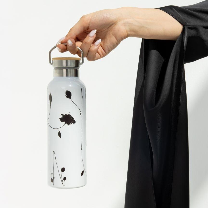 Selected Lines luxury tumbler with floral design held by hand with stainless steel lid and handle