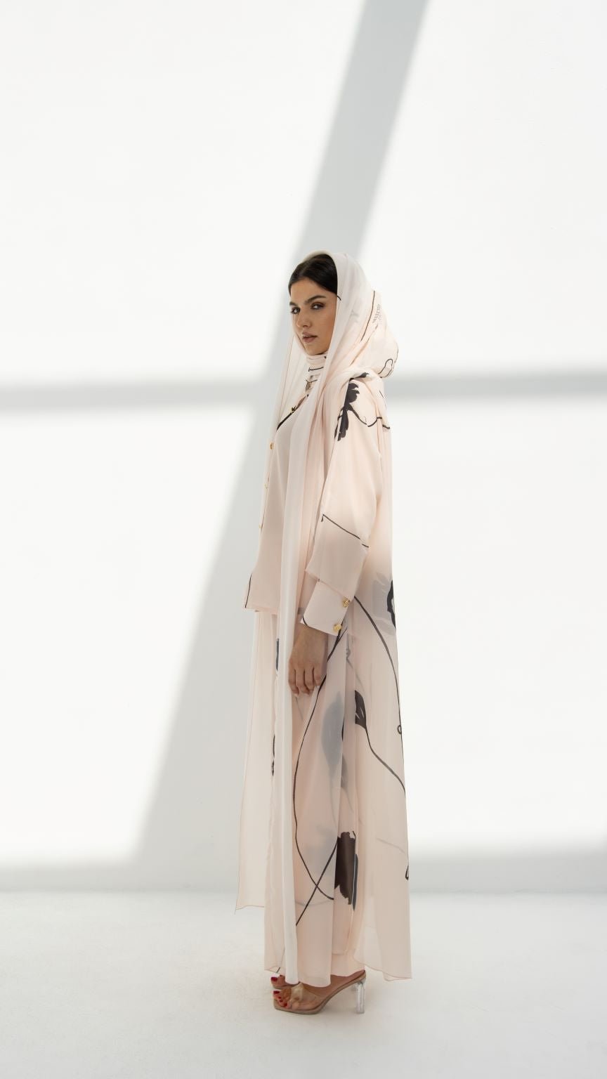 Selected Lines modest hoodie abaya in light beige with abstract black print worn by woman with hood up
