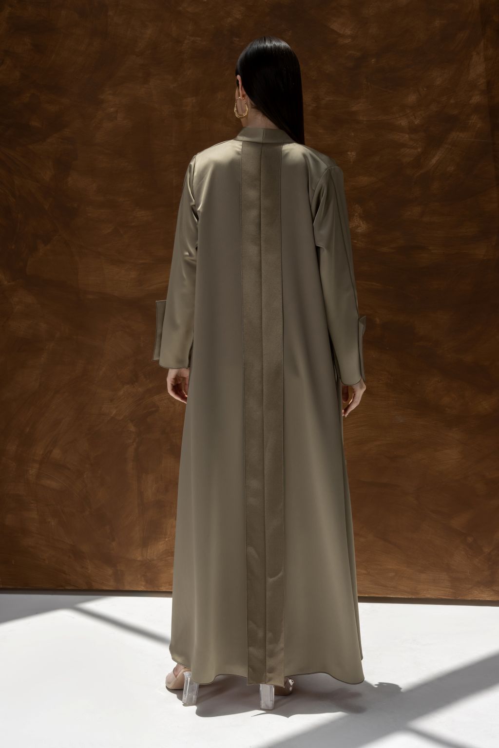 Back view of a woman wearing ModiSquare luxury abaya for women in a neutral beige color by Selected Lines