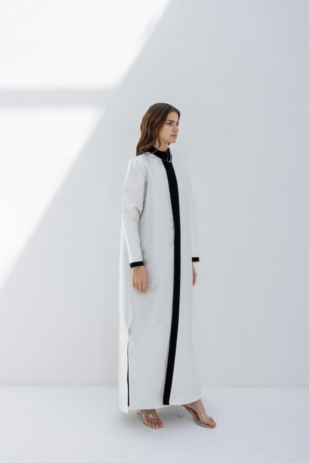 Selected Lines white abaya with black trim worn by woman showcasing Nka Design luxury fashion