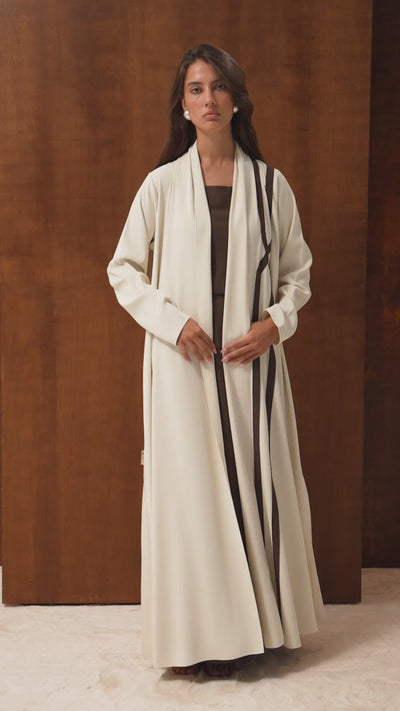 Video of the Aurette abaya by Selected Lines — off-white Japanese crepe with a brown cross line design, cut A-line