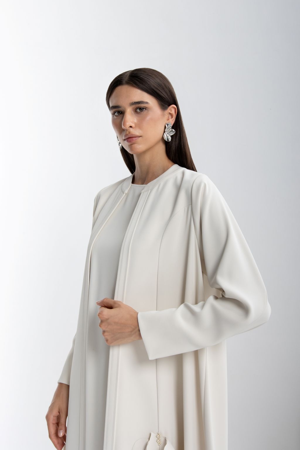 Elegant model wearing a refined luxury evening abaya in soft white fabric with delicate details