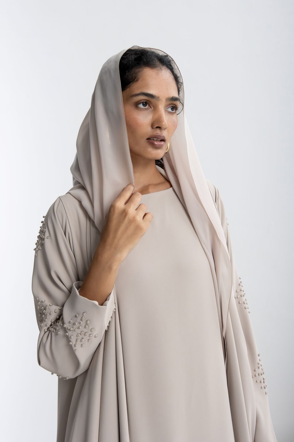 Refined neutral evening abaya with elegant detailing and matching hijab for stylish occasions