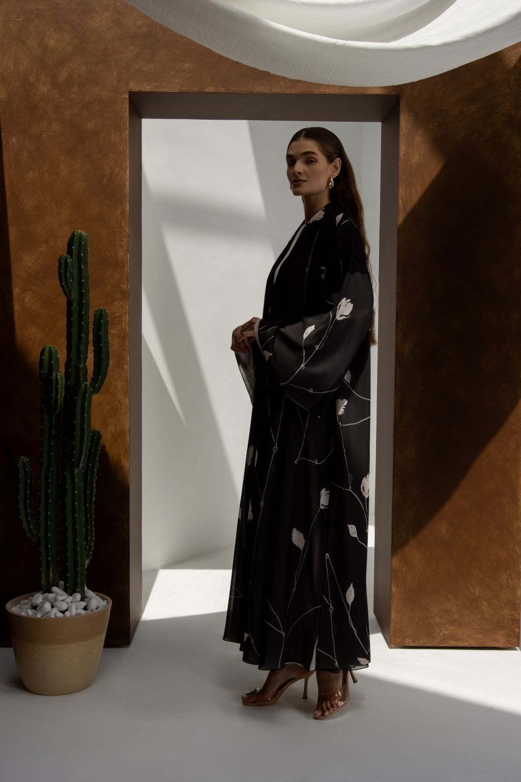 Selected Lines signature leaves black abaya worn by woman in stylish modern setting