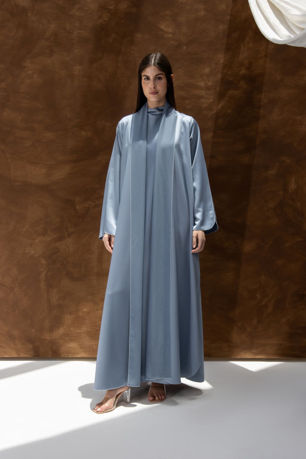 Selected Lines silhouette abaya with refined design in soft blue fabric worn by model with long sleeves